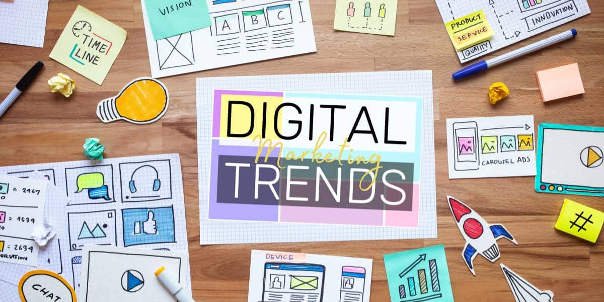 Digital marketing trends written on a piece of paper, surrounded by other pieces of marketing brainstorming material.