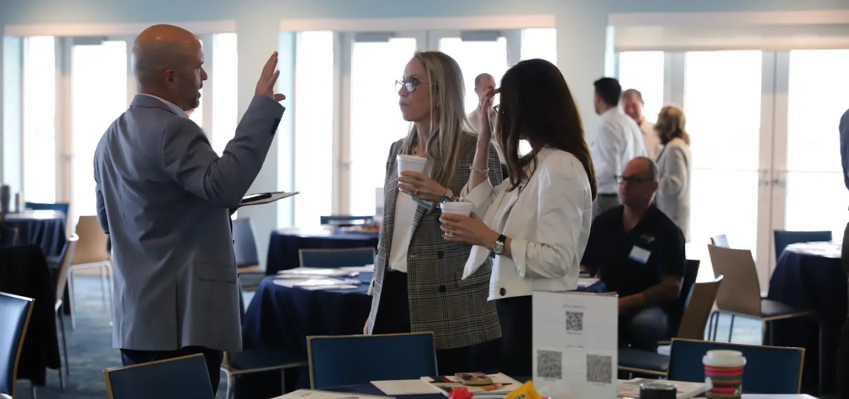 Business coach speaking with professionals during a leadership networking event