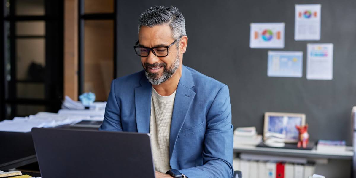 Business professional reviewing business metrics on a laptop in an office setting