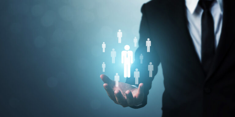 Business leader demonstrating how to develop leadership skills by selecting and managing team members with digital icons floating above open hand