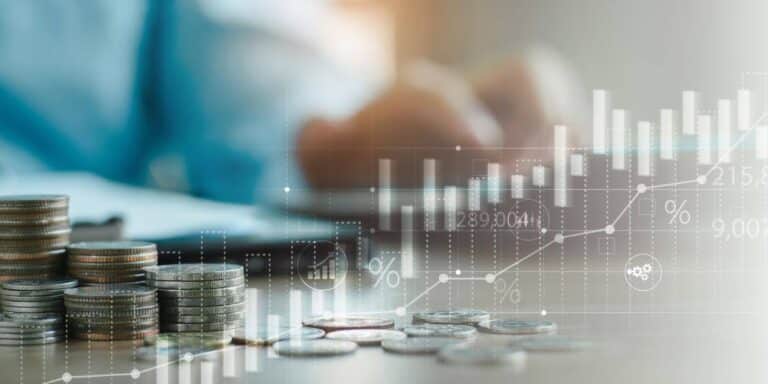 Stacked coins on a table representing financial growth, with an overlay of digital bar charts and percentage signs illustrating revenue growth strategies.